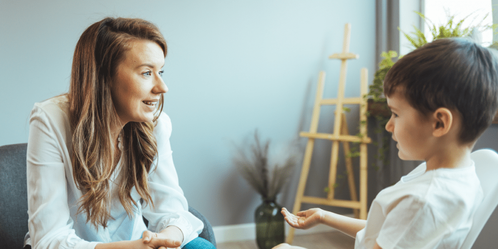 A woman speaking with a young child, representing the role of a Guardian ad litem (GAL) in the Charlotte courts.