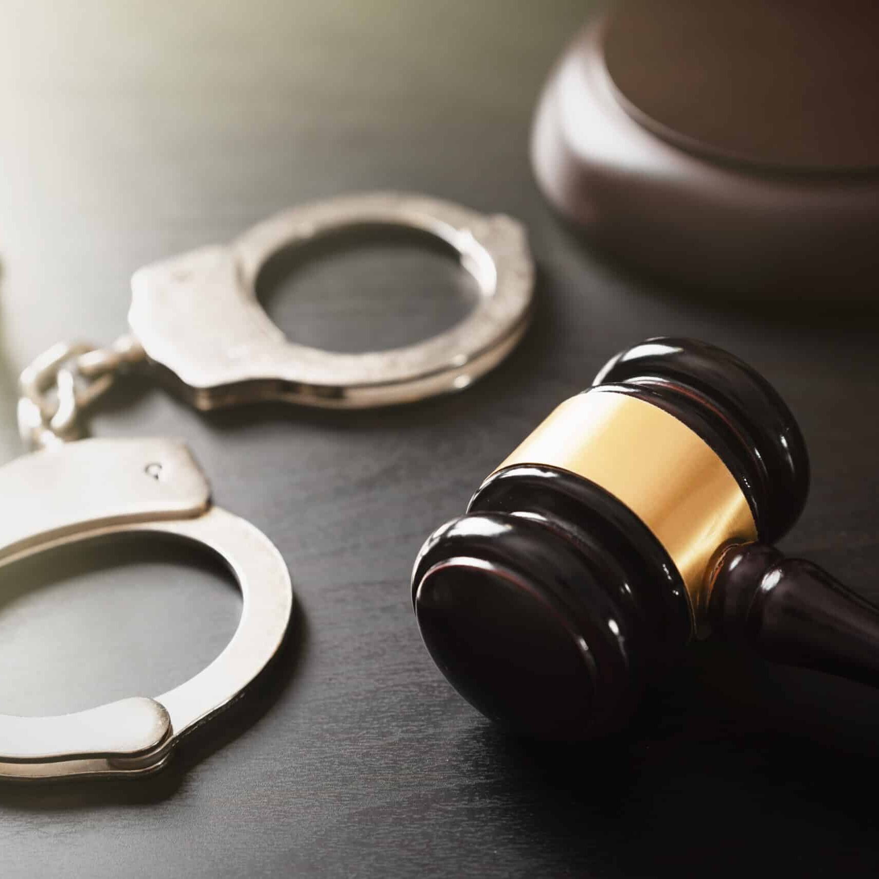 Crime and violence concept with handcuffs Handcuffs and wooden gavel. Crime and violence concept.